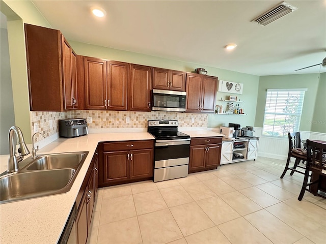 kitchen with sink, light tile patterned floors, stainless steel appliances, and tasteful backsplash