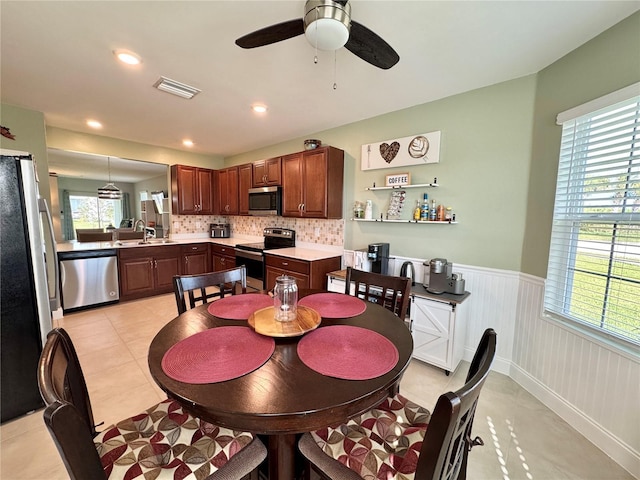 tiled dining area featuring ceiling fan and sink