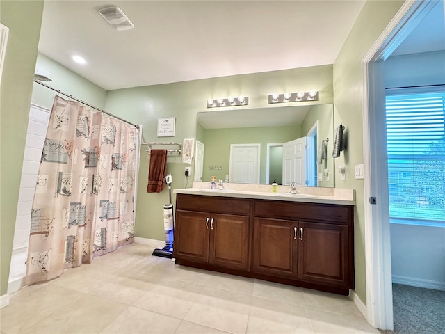 bathroom featuring tile patterned flooring, vanity, and shower / tub combo with curtain