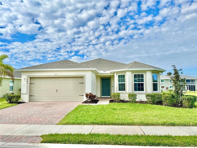 ranch-style house featuring a garage and a front lawn