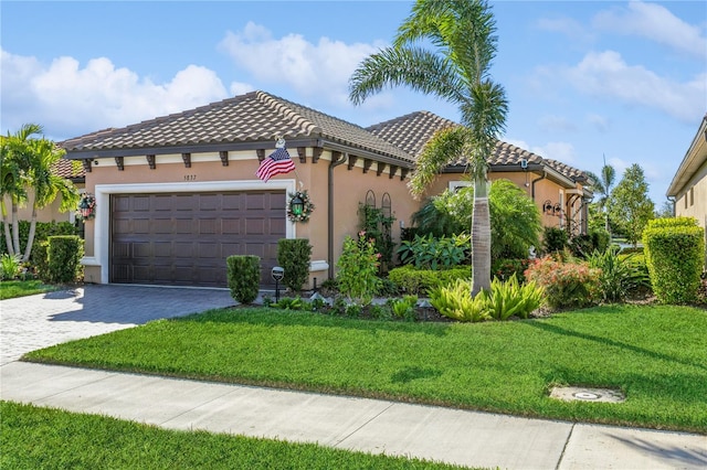 mediterranean / spanish-style house featuring a front lawn and a garage