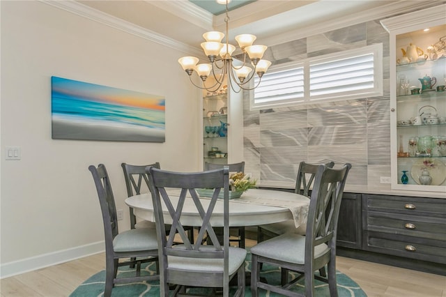 dining room with light hardwood / wood-style floors, an inviting chandelier, and crown molding