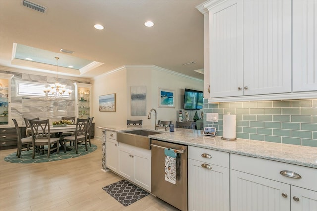 kitchen featuring white cabinets, a raised ceiling, dishwasher, and sink