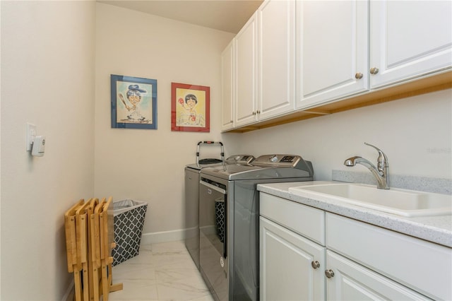 laundry room featuring sink, washing machine and dryer, and cabinets