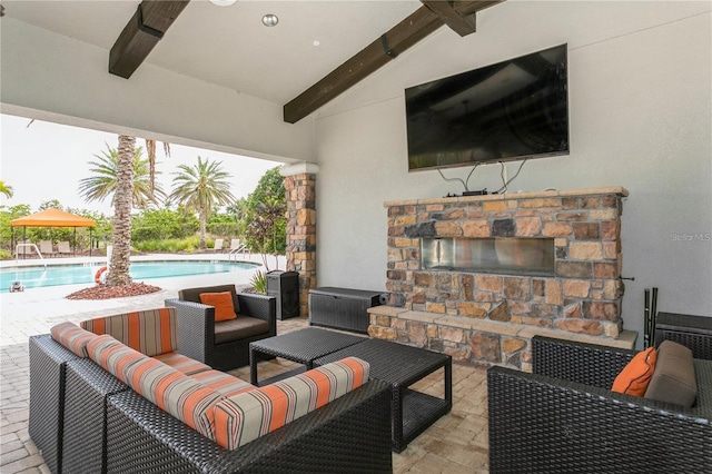 view of patio / terrace with ceiling fan and an outdoor living space with a fireplace