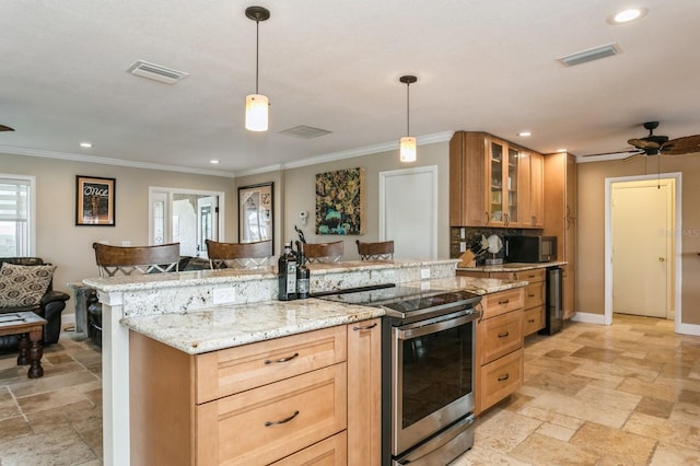 kitchen with light stone counters, ceiling fan, electric stove, decorative light fixtures, and a breakfast bar area