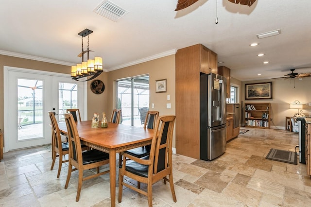 dining space with ceiling fan with notable chandelier, crown molding, and french doors