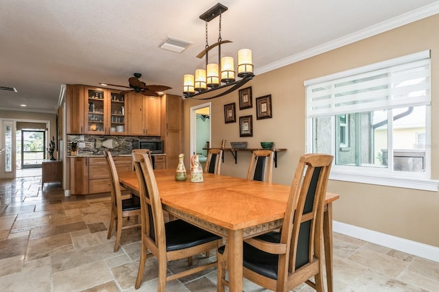 dining space with ceiling fan with notable chandelier and crown molding