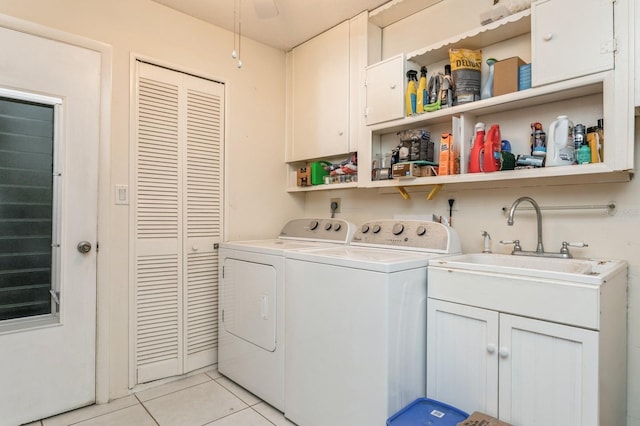 laundry room featuring cabinets, sink, washer and clothes dryer, and light tile patterned flooring