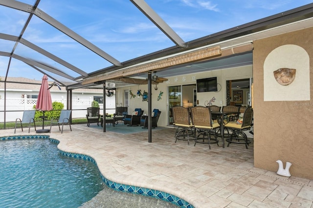 view of swimming pool with a lanai, ceiling fan, and a patio area