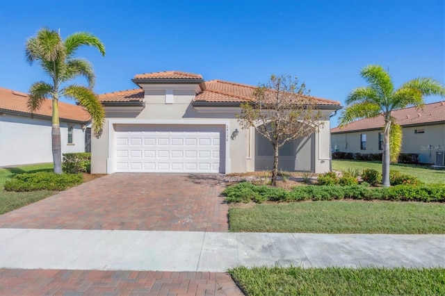 mediterranean / spanish-style home featuring a front lawn and a garage