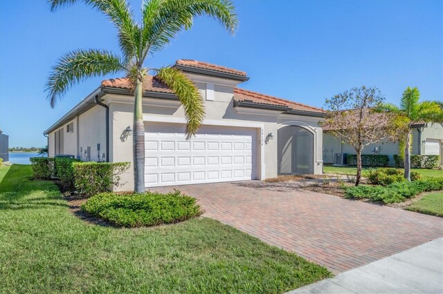 mediterranean / spanish-style home featuring a garage and a front lawn