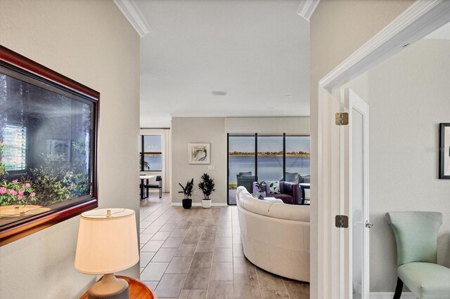 living room featuring a water view, a wealth of natural light, and crown molding