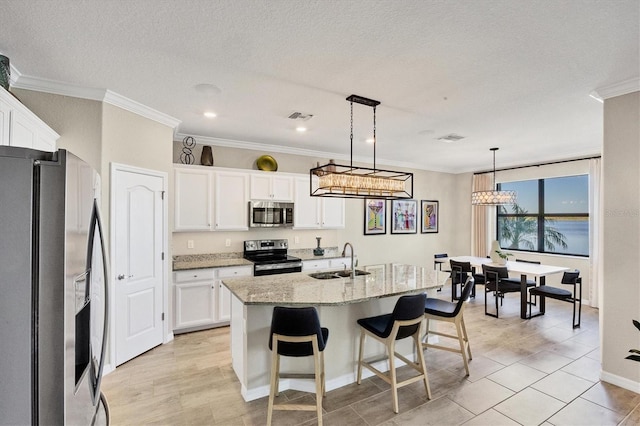 kitchen with white cabinets, stainless steel appliances, hanging light fixtures, and sink