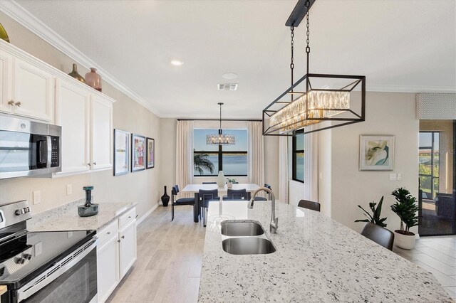 kitchen with white cabinetry, sink, light stone countertops, and appliances with stainless steel finishes