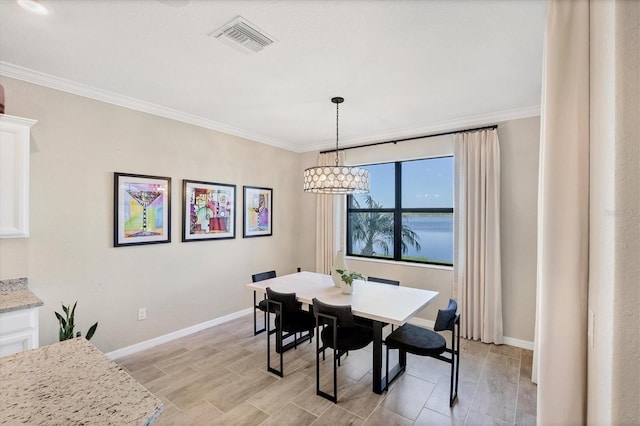 dining room with light hardwood / wood-style floors and crown molding