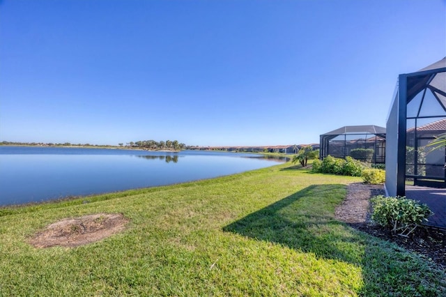 view of yard with glass enclosure and a water view