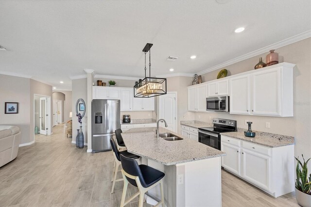 kitchen featuring a center island with sink, white cabinetry, sink, and appliances with stainless steel finishes