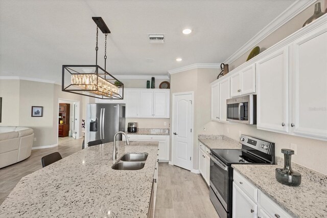 kitchen with sink, light stone countertops, decorative light fixtures, white cabinetry, and stainless steel appliances