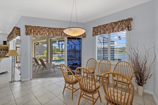 dining room with a water view, a wealth of natural light, and light tile patterned flooring