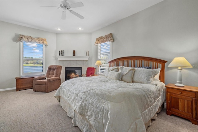 carpeted bedroom with ceiling fan, a fireplace, and multiple windows