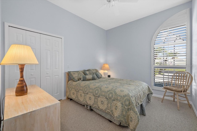 carpeted bedroom with ceiling fan and a closet