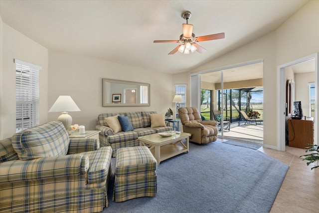 carpeted living room with ceiling fan and vaulted ceiling