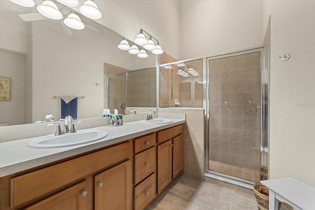 bathroom with tile patterned flooring, vanity, ceiling fan, and a shower with shower door