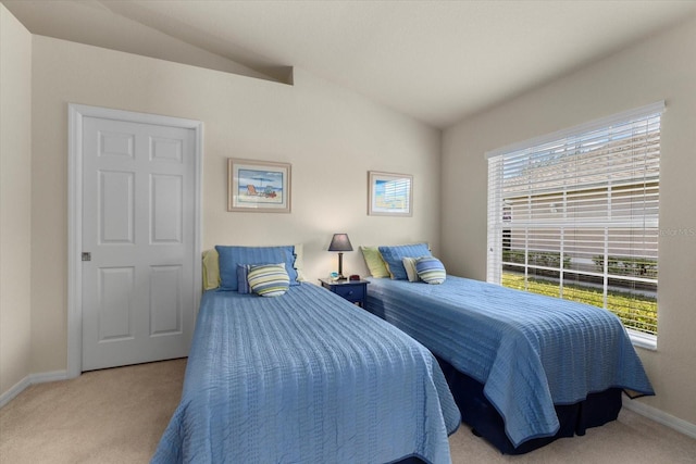 bedroom with light colored carpet and vaulted ceiling