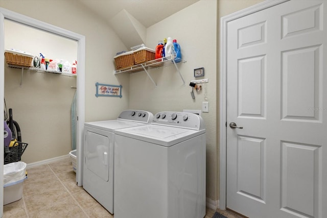 clothes washing area with washing machine and dryer and light tile patterned floors