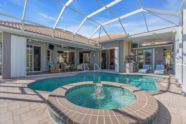 view of pool featuring an in ground hot tub, glass enclosure, ceiling fan, and a patio area