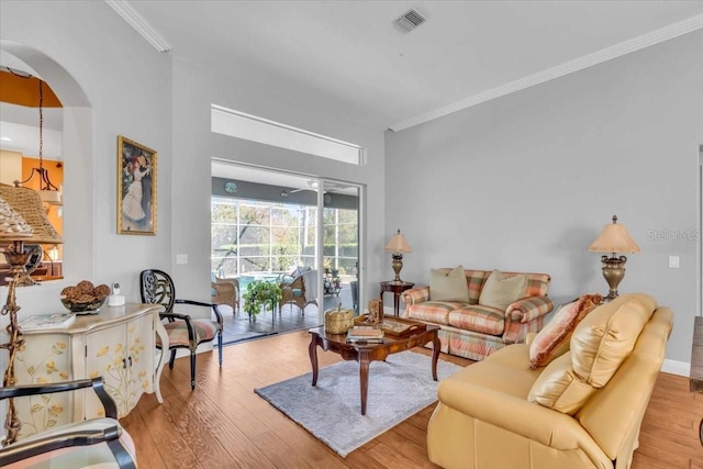 living room with light wood-type flooring and crown molding