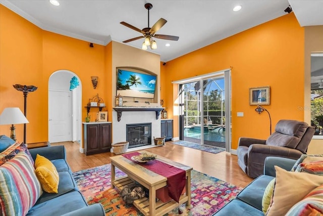 living room with light hardwood / wood-style floors, ceiling fan, and crown molding