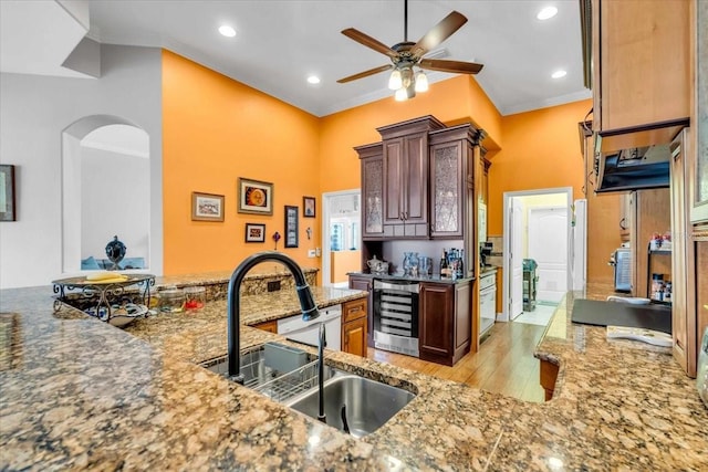 kitchen with sink, wine cooler, light hardwood / wood-style flooring, kitchen peninsula, and crown molding