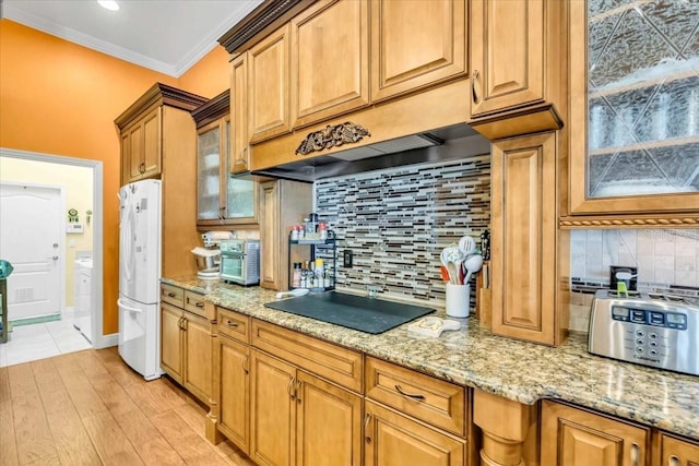 kitchen featuring light stone countertops, light hardwood / wood-style flooring, white refrigerator, crown molding, and black electric stovetop