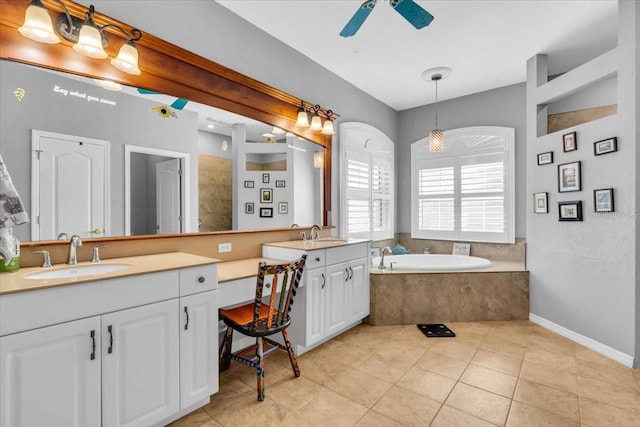 bathroom with tile patterned floors, ceiling fan, vanity, and tiled tub