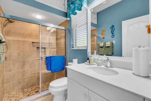 bathroom with toilet, an enclosed shower, and vanity