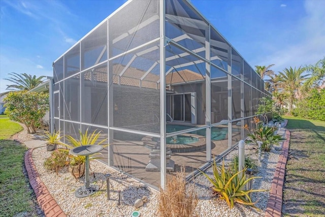 exterior space with a lanai and an in ground hot tub