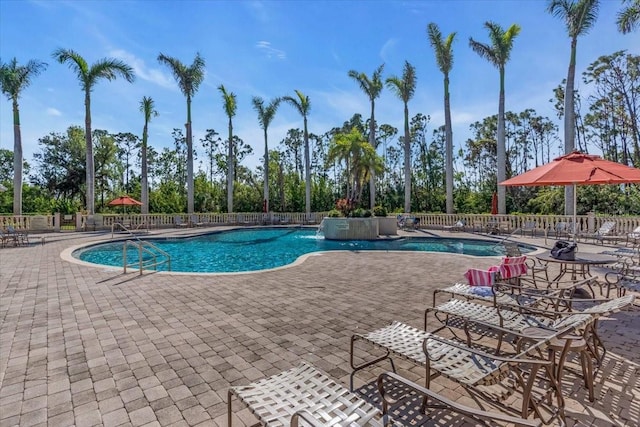 view of swimming pool with pool water feature and a patio area