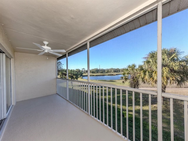 balcony with ceiling fan and a water view