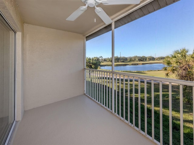 balcony with ceiling fan and a water view