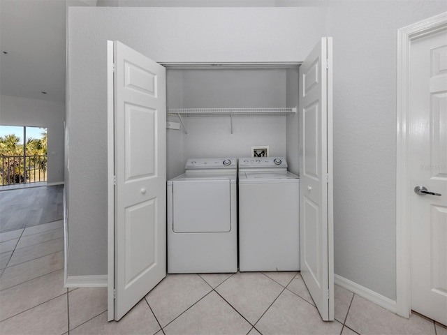 laundry room with light tile patterned floors and washing machine and dryer