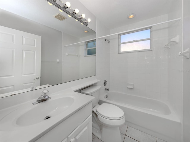 full bathroom with tile patterned floors, vanity, tiled shower / bath combo, and toilet