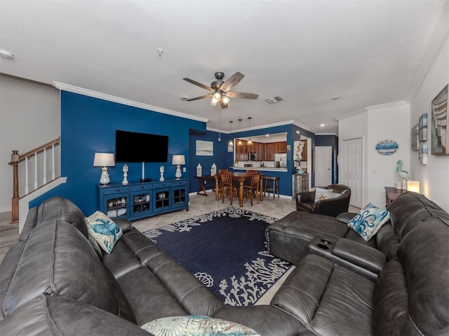 living room with ceiling fan, light tile patterned floors, a textured ceiling, and ornamental molding