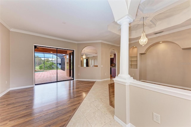 interior space featuring ornate columns, crown molding, and hardwood / wood-style floors