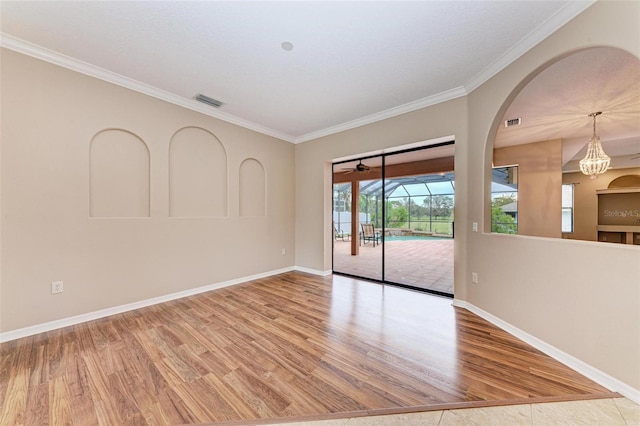 unfurnished room featuring light hardwood / wood-style floors, crown molding, and a notable chandelier