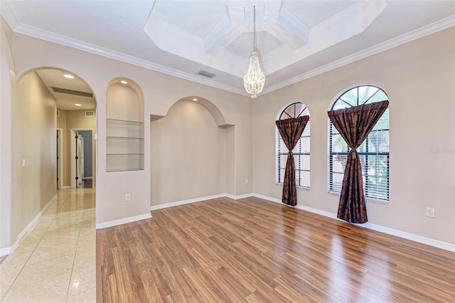 empty room with crown molding, coffered ceiling, and light wood-type flooring