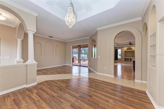 interior space featuring light hardwood / wood-style floors, ceiling fan with notable chandelier, and ornamental molding