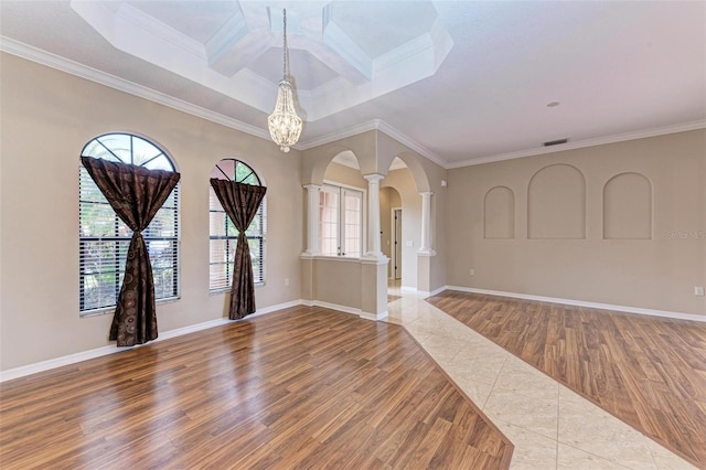 unfurnished room featuring wood-type flooring, ornate columns, a wealth of natural light, and ornamental molding