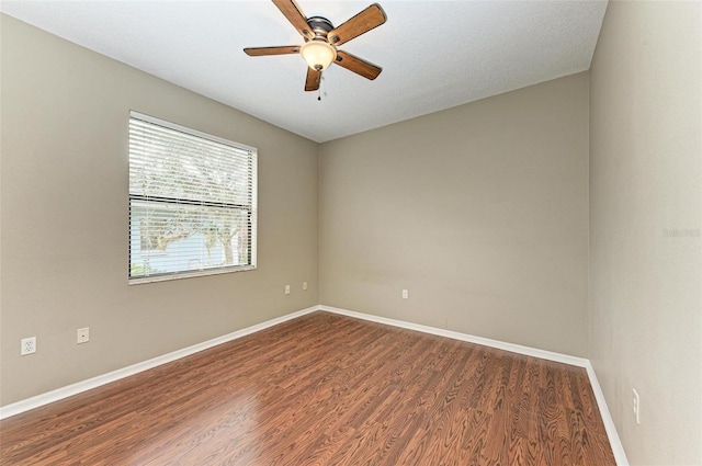 empty room featuring a textured ceiling, ceiling fan, and dark wood-type flooring